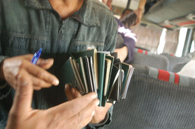 A bus driver gathers Iraqi passports in preparation for a journey to Baghdad