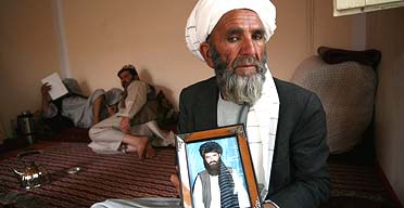 Abdullah Mujahid's father holds a photo of his son