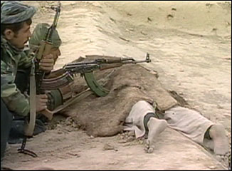 Alliance soldier rest guns on a corpse at Qala-i-Janghi