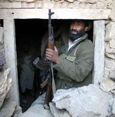 An Afghan soldier sits in the entrance of one of the Tora Bora caves