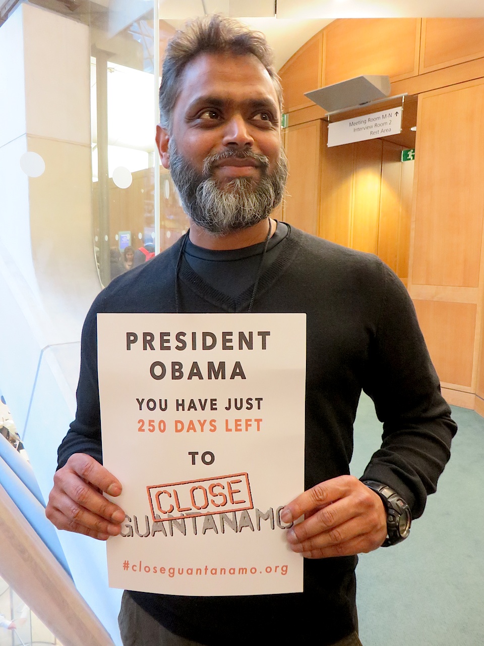 Former Guantanamo prisoner Moazzam Begg, in Portcullis House, in London (across the road from the Houses of Parliament), holding a poster reminding President Obama that, on May 14, he has just 250 days left to close Guantanamo as he promised when he took office in January 2009 (Photo: Andy Worthington). Former Guantanamo prisoner Moazzam Begg, in Portcullis House, in London (across the road from the Houses of Parliament), holding a poster reminding President Obama that, on May 14, he has just 250 days left to close Guantanamo as he promised when he took office in January 2009 (Photo: Andy Worthington).