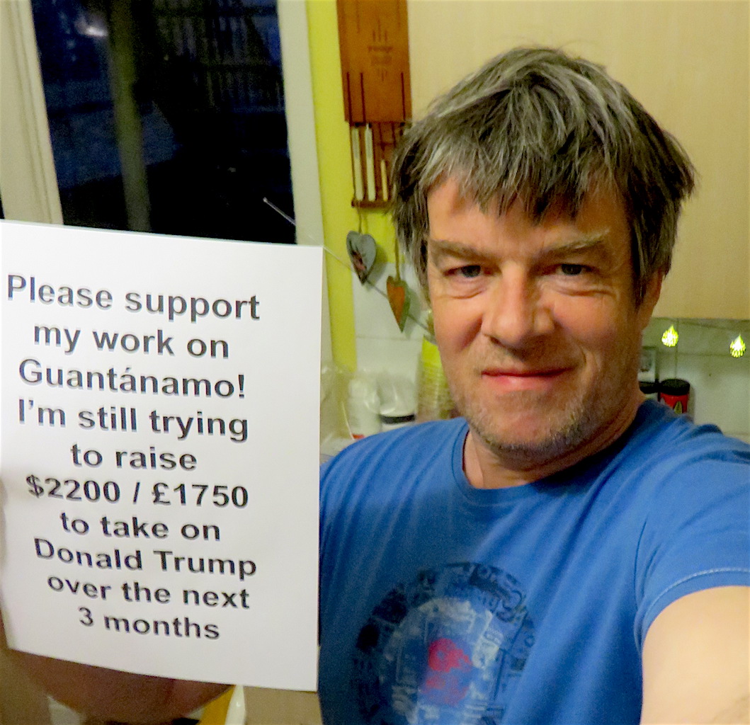 Andy Worthington holding up a poster advertising his fundraiser in March 2017.