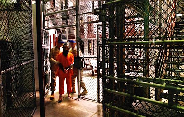 A prisoner being moved by guards in Camp Six at Guantanamo (Photo: J. Moore, Getty Images).