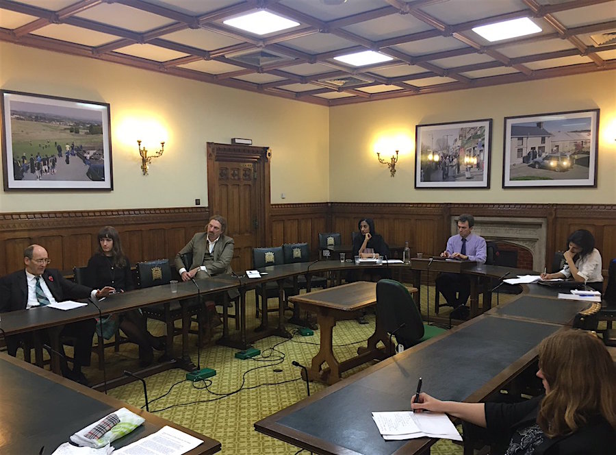 The Parliamentary meeting on Guantanamo on November 1, 2016, with Andrew Tyrie MP on the left, Chris Law MP in front of the door, Alka Pradhan to his left, and Tom Brake MP beneath the two photos on the wall (photo via Gitmo Watch).